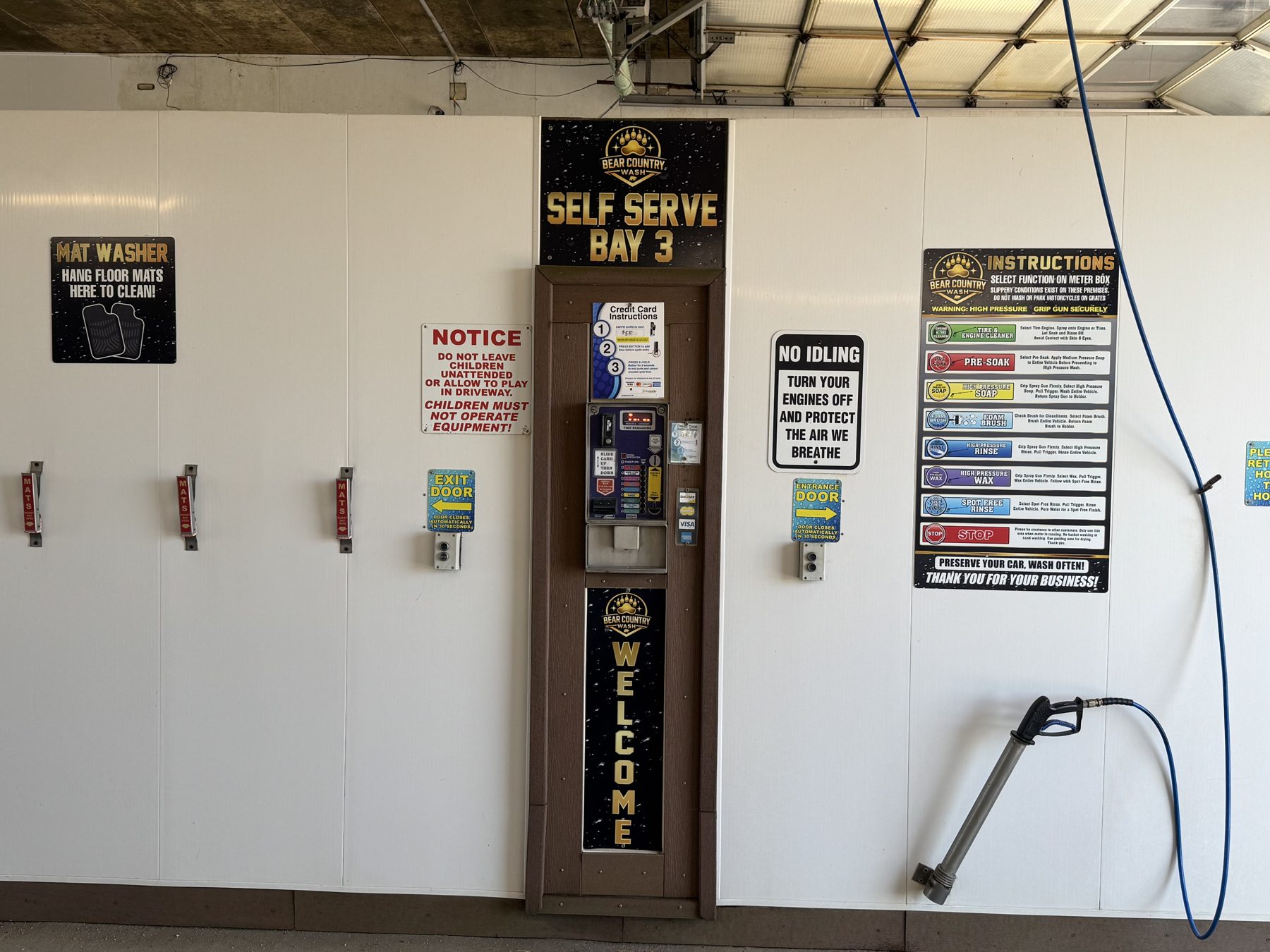 Self-serve wash bay interior with instructions and payment terminal